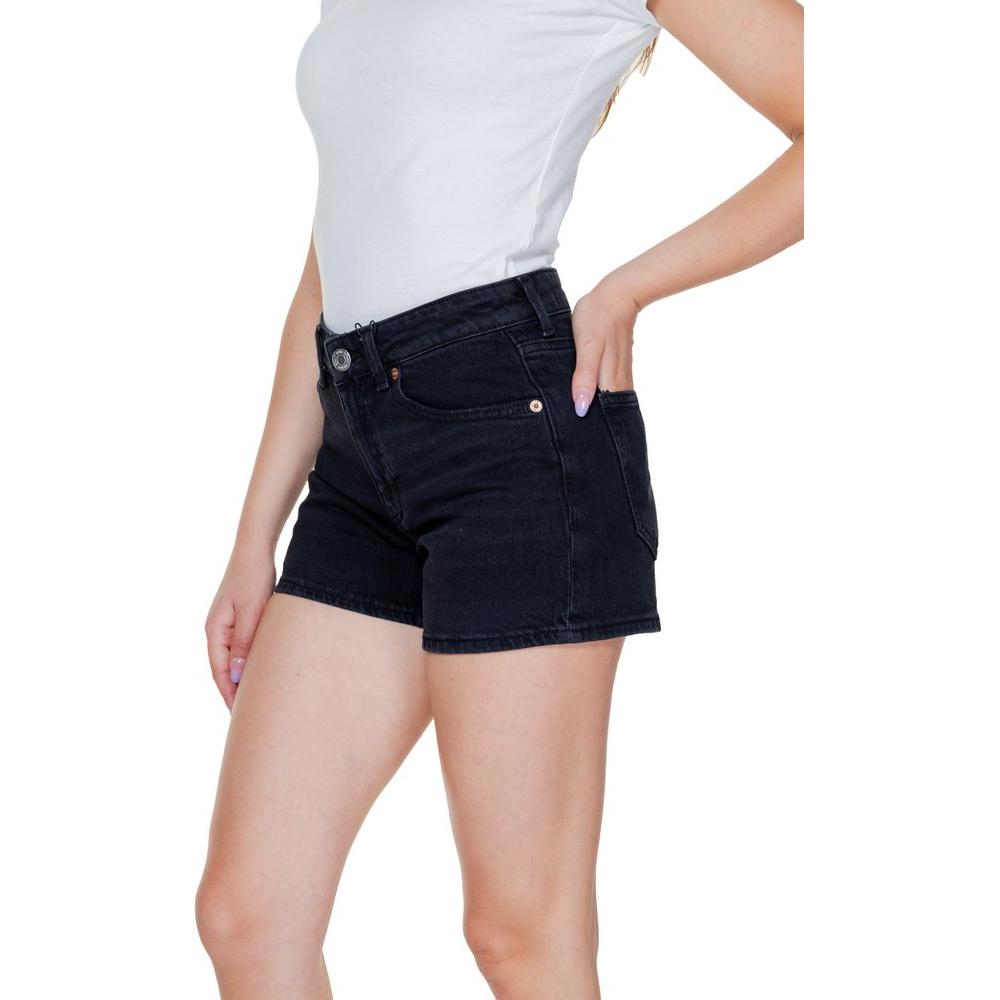 Woman wearing Vero Moda black cotton shorts, ideal for spring and summer. Made of 99% cotton and 1% elastane for comfort and style.