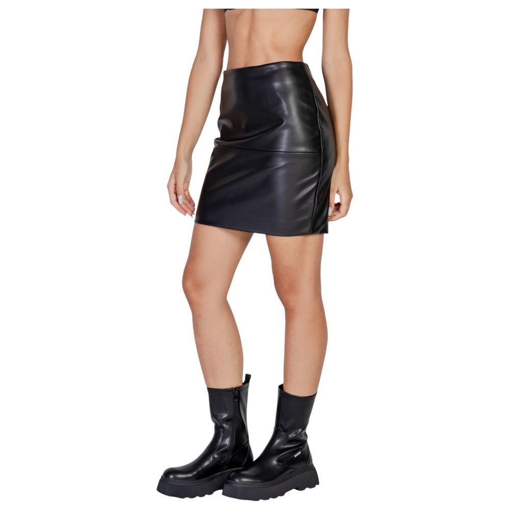 Woman wearing ICHI Black Polyethylene Skirt from Fall Winter Collection, 100% polyurethane, styled with black boots.