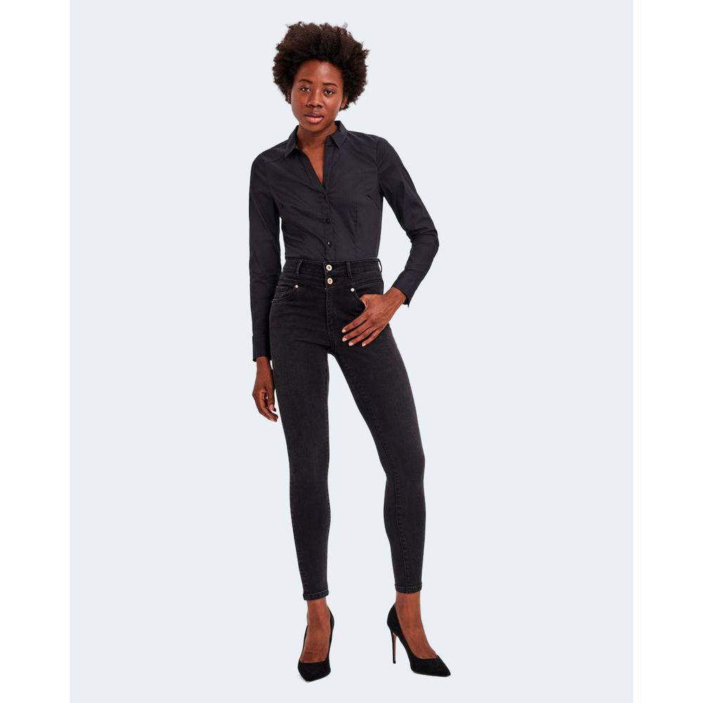 Woman wearing Vero Moda black long-sleeve shirt and high-waisted black pants with high heels.