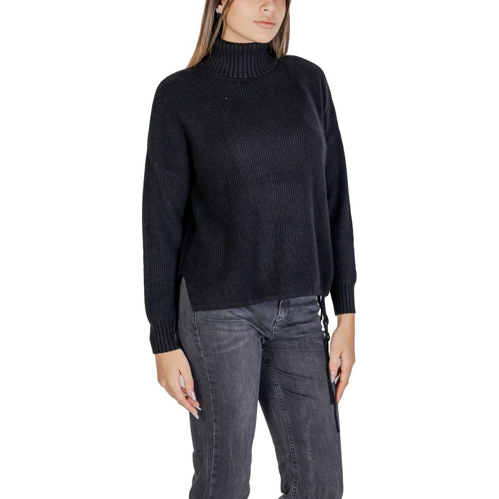 Woman wearing Sandro Ferrone black viscose sweater, part of the women's knitwear fall/winter collection.