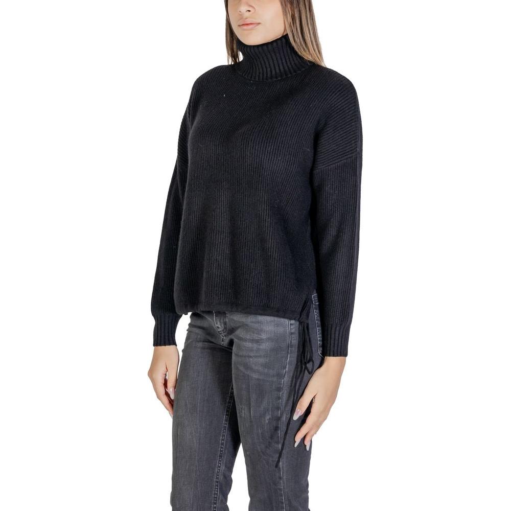 Woman wearing Sandro Ferrone black viscose sweater from fall/winter collection, featuring long sleeves and turtleneck.