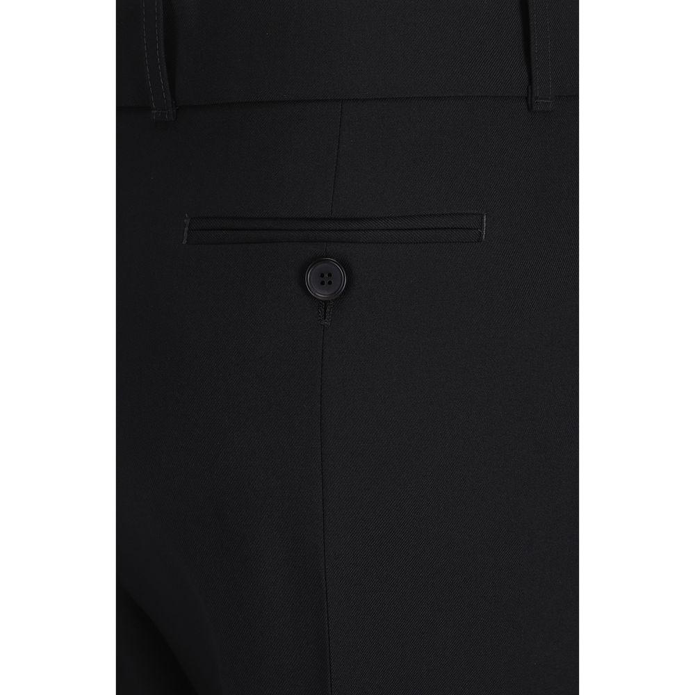 Close-up of Alexander McQueen wool pants with a buttoned welt back pocket, monochrome black, showcasing luxury design details.