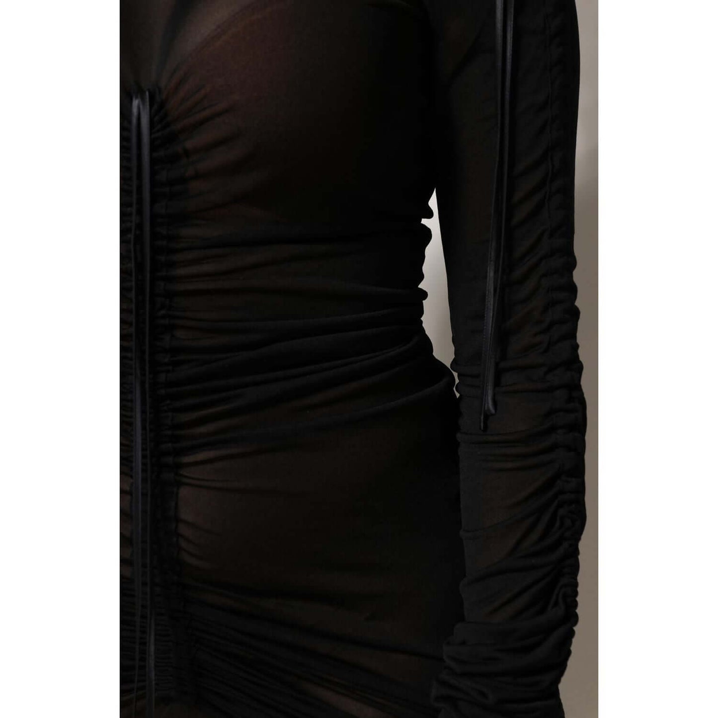 Dolce & Gabbana black mesh bodycon dress with long sleeves, close-up view showing intricate ruched details, elegant and exclusive design.