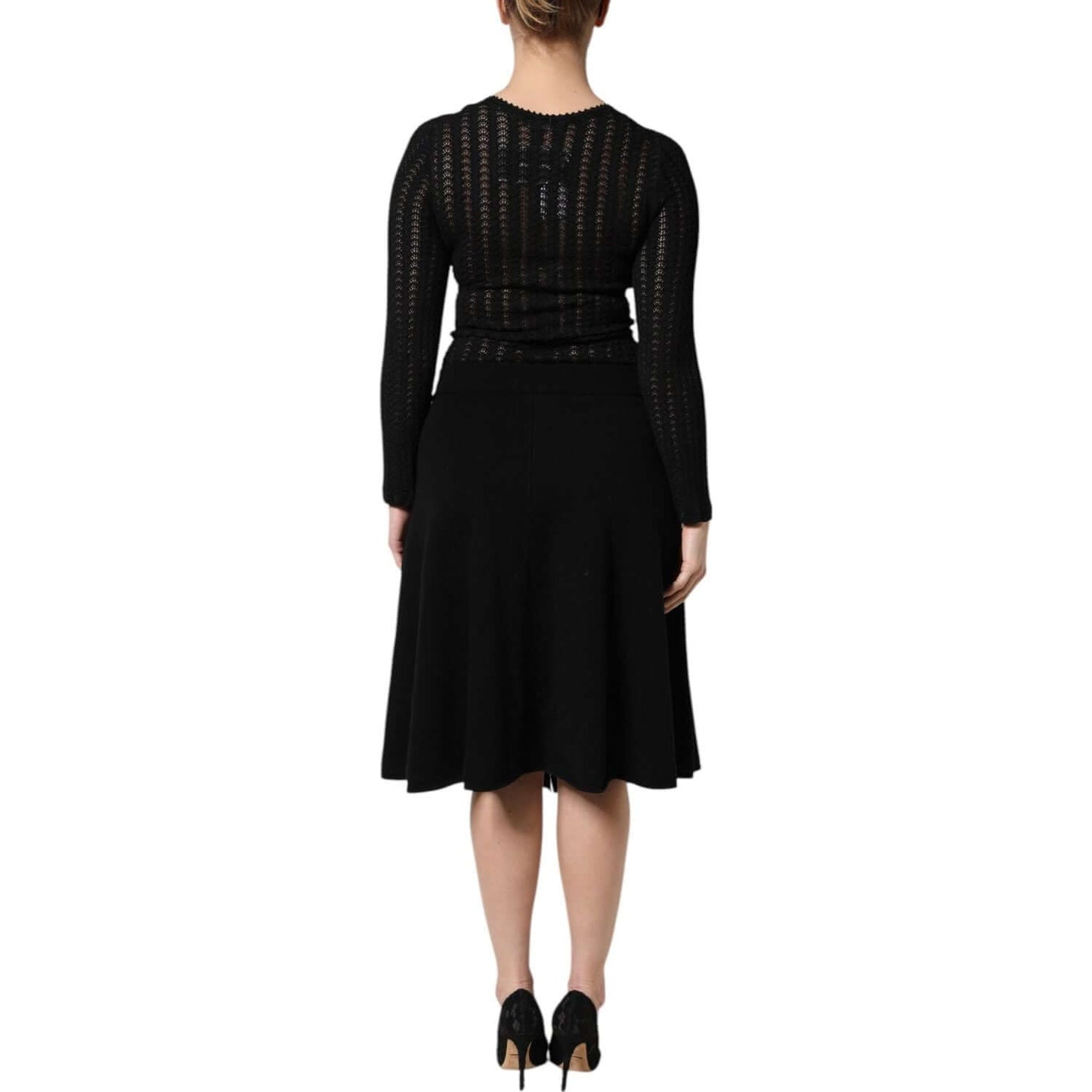 Back view of a woman wearing a Dolce & Gabbana black cashmere midi dress with long sleeves and A-line silhouette.