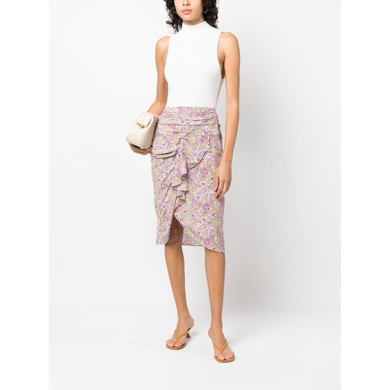 Woman wearing IRO graphic-print knee-length skirt in beige with draped and ruched detailing, styled with a white top and heels.