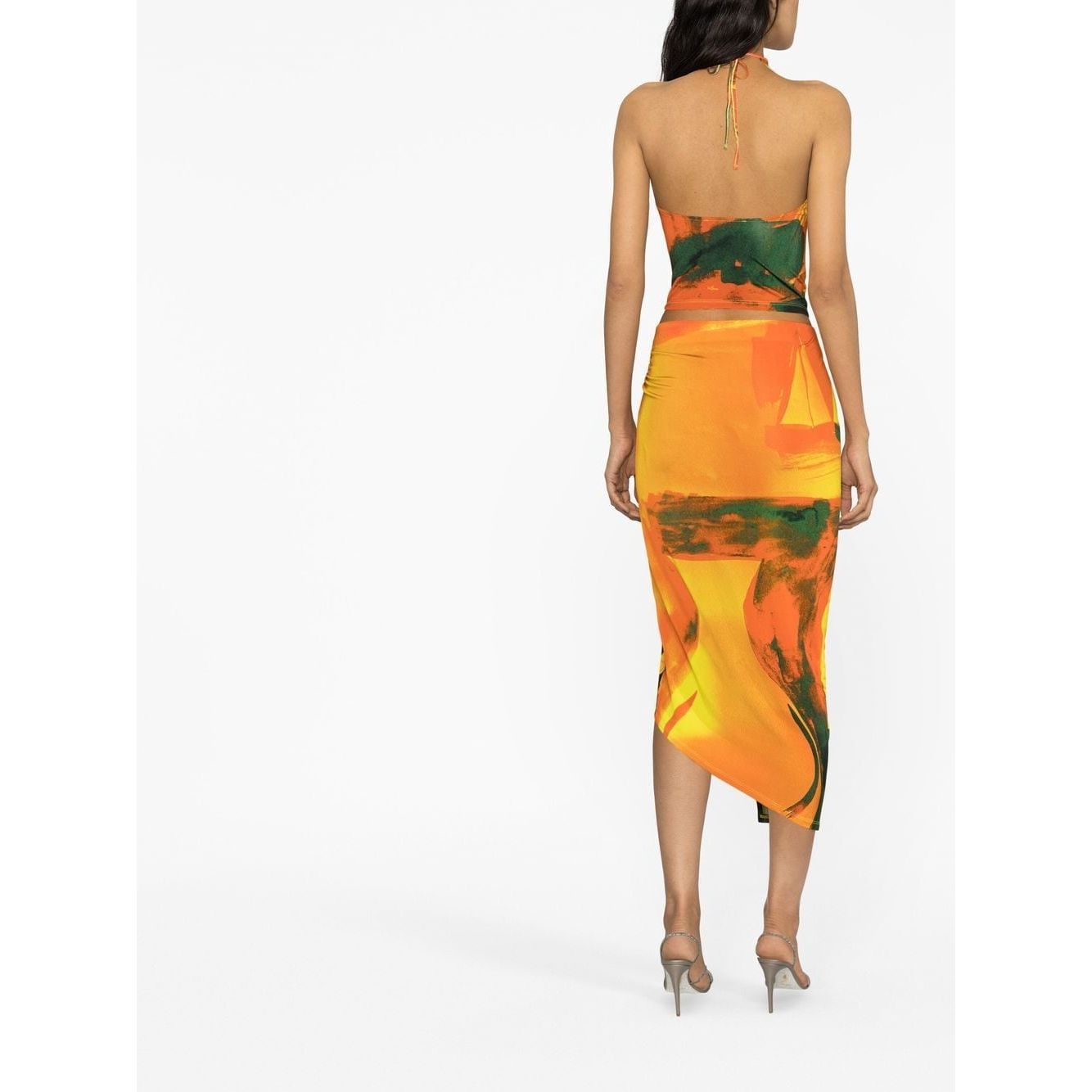 Back view of a model in a Louisa Ballou multicolour wrap skirt with abstract pattern, high-waisted design, and asymmetric hem.
