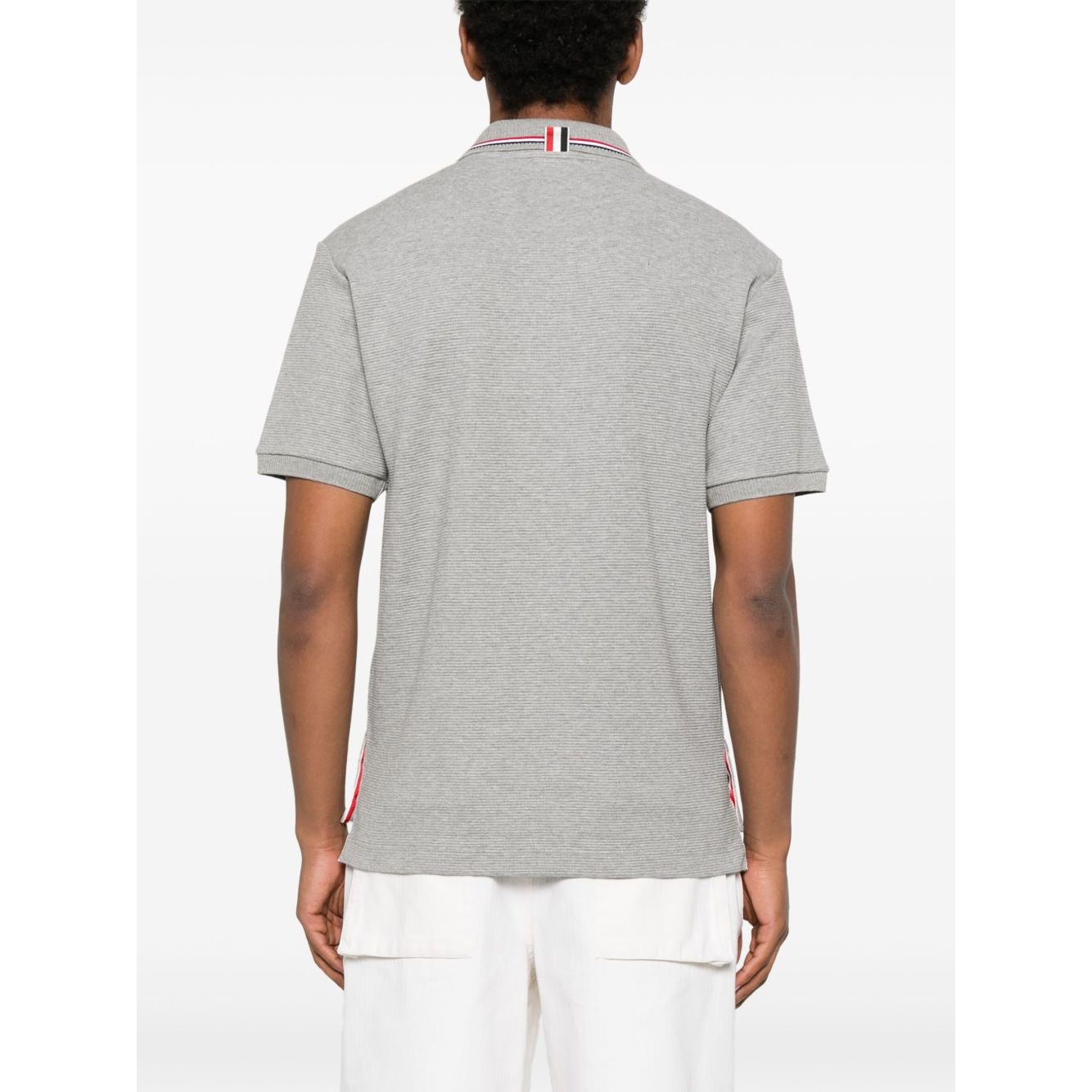 Back view of a Thom Browne T-shirts and Polos Light Grey Rwb cotton polo shirt with button placket and polo collar, worn by a model.