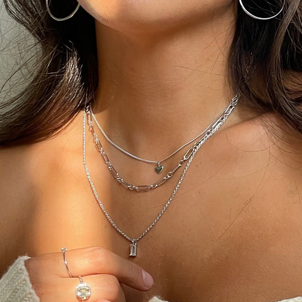 Woman wearing layered silver necklaces and hoop earrings showcasing 24KAE JEWELS JEWELRY Mod. 32422S design elegance.