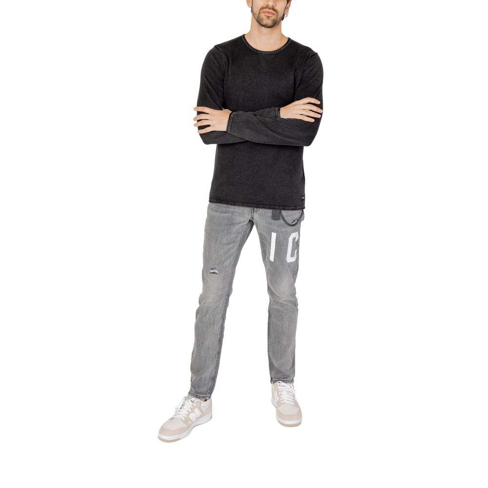 Model wearing Jack Jones Black Cotton Sweatshirt with folded arms, paired with gray jeans and white sneakers.