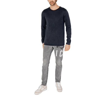 Man wearing Jack Jones Blue Cotton Sweatshirt with gray jeans and white sneakers, showcasing a casual refined look.