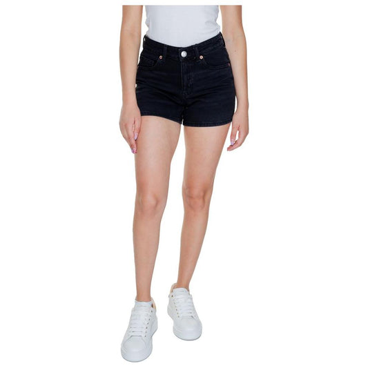 Woman wearing Vero Moda black cotton shorts, spring/summer collection, styled with white sneakers, perfect for casual wear.