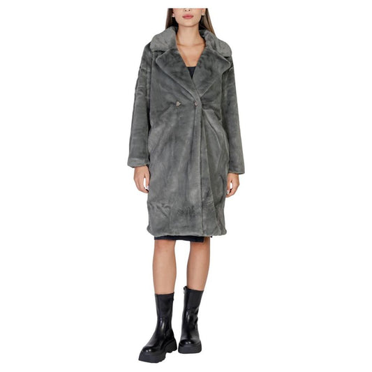 Woman wearing ICHI black polyester coat, fall/winter collection, 100% polyester, featuring elegant design and long sleeves for women.