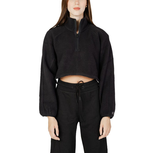 Woman wearing a Calvin Klein Sport black polyester sweater with a cropped design and zip closure, perfect for casual and sporty outfits.