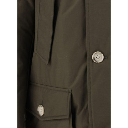 Close-up of Woolrich Green Cotton Parka with button details and front pockets, featuring the iconic brand patch on neckline and padded design.