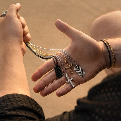 Hand holding multiple necklaces from AN JEWELS JEWELRY Mod. AA.C256PBK, showcasing various pendants in different designs.