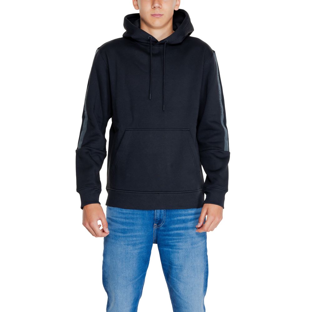 Model wearing a Calvin Klein Jeans Black Cotton Hoodie with drawstring hood and front pocket.