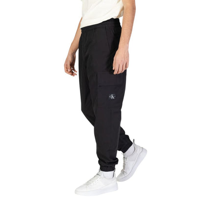 Man wearing Calvin Klein Jeans Black Cotton Joggers (Workout Pants) with elastic waistband and pocket design.