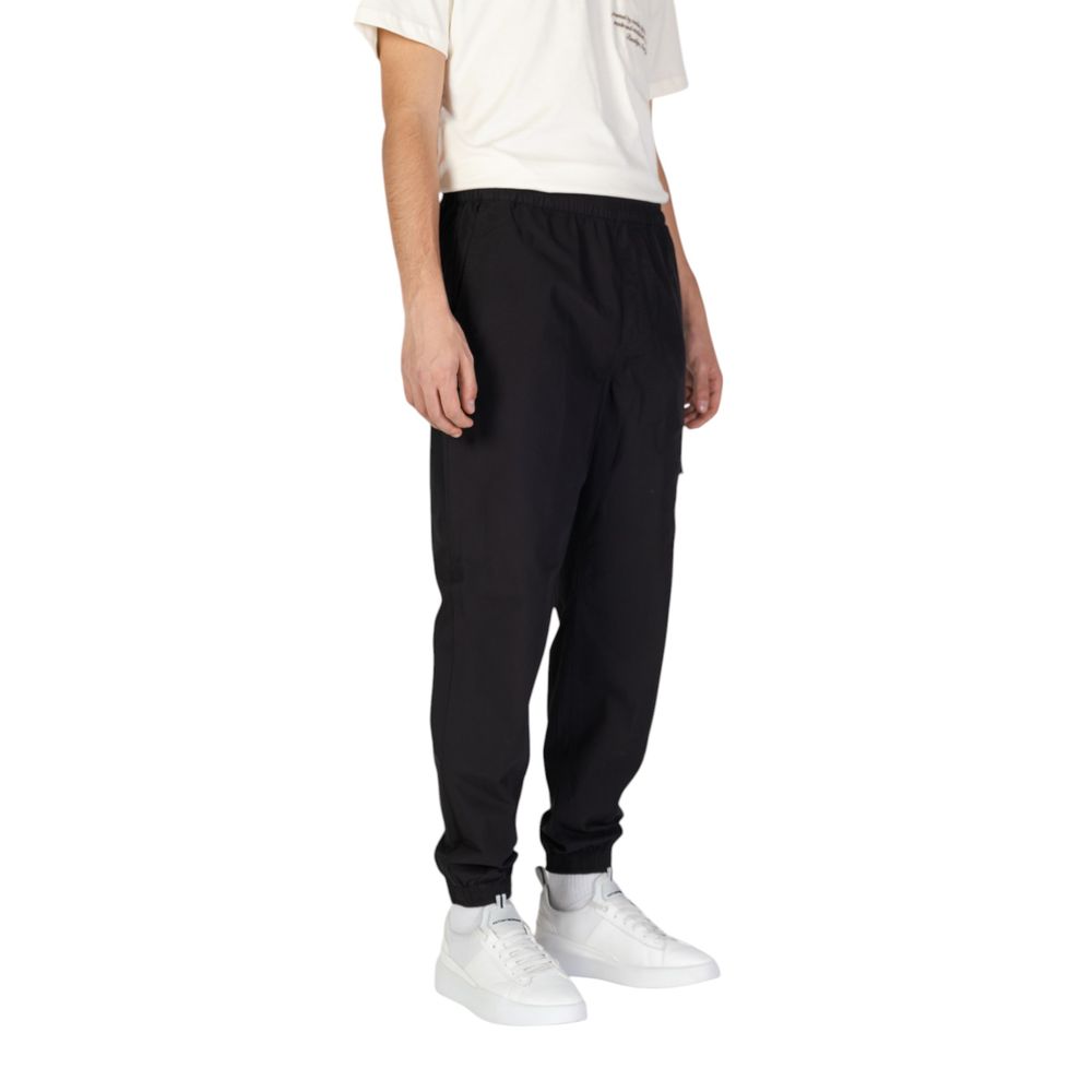 Man wearing Calvin Klein Jeans Black Cotton Joggers (Workout Pants) with elastic waistband and practical pockets for casual sport use.