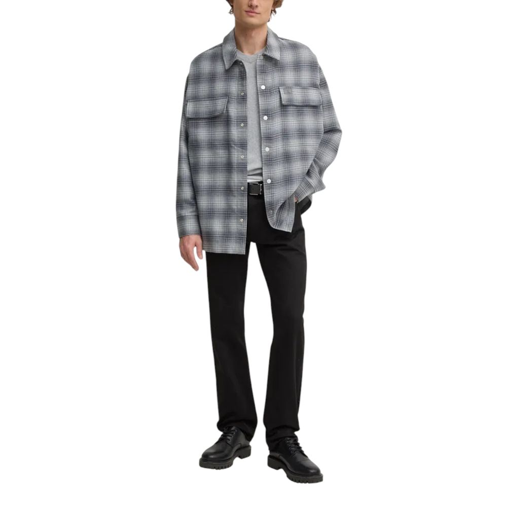 Model wearing Calvin Klein Jeans Black Cotton Relaxed Fit Jeans with a plaid shirt and boots, showcasing a casual look.