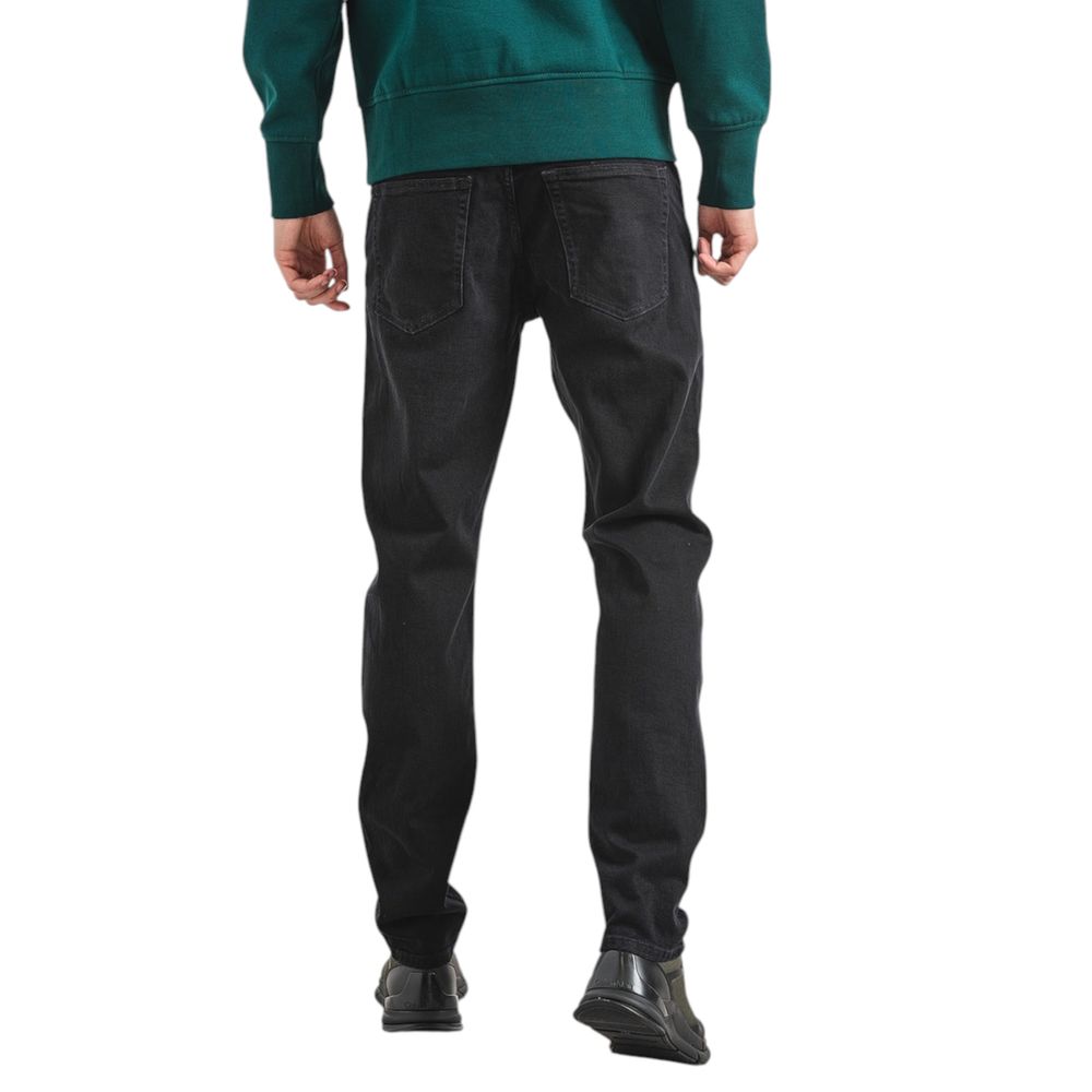 Back view of a man wearing Calvin Klein Jeans Black Cotton Slim Fit Jeans with tapered design
