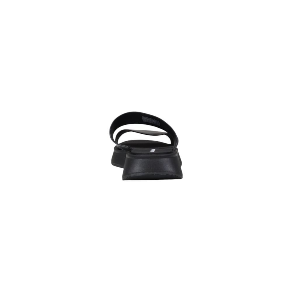 Calvin Klein Jeans Black Leather Flat Sandals rear view showcasing minimalist design and durable sole for comfort and style.