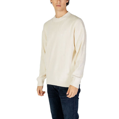 Model wearing Calvin Klein Jeans Cream Cotton Sweatshirt with ribbed texture and crew neck for a stylish and comfortable look.