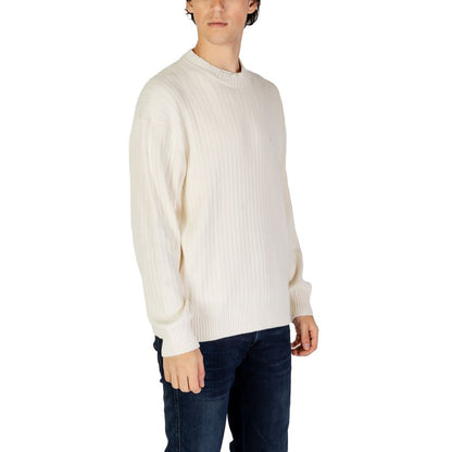 Man wearing a Calvin Klein Jeans Cream Cotton Sweatshirt with ribbed texture and crew neck, styled for modern casual wear.