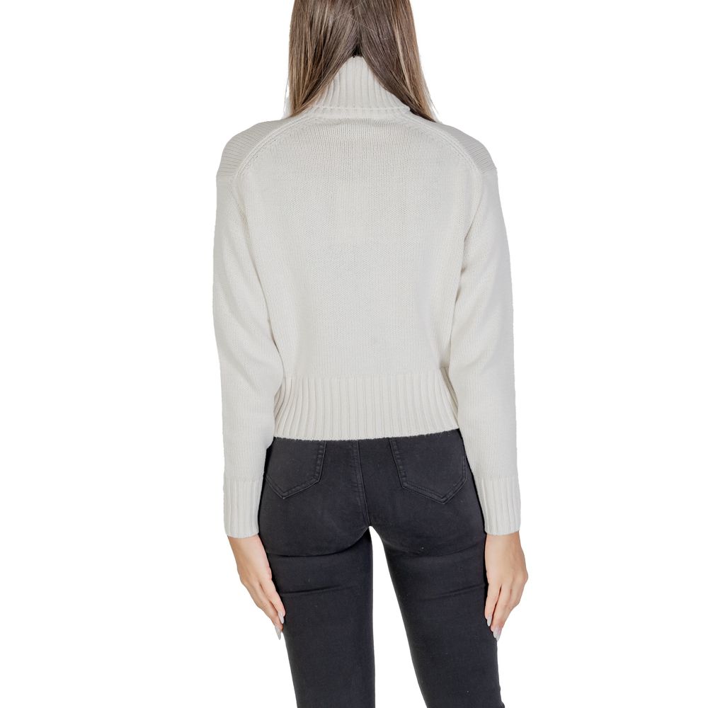 Back view of Calvin Klein Jeans Cream Cotton Turtleneck worn by woman, showcasing ribbed design and cropped fit.