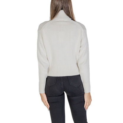 Back view of Calvin Klein Jeans Cream Cotton Turtleneck worn by woman, showcasing ribbed design and cropped fit.