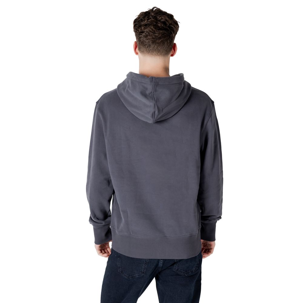 Back view of a man wearing a Calvin Klein Jeans Gray Cotton Hoodie, showcasing urban New York style and comfort.