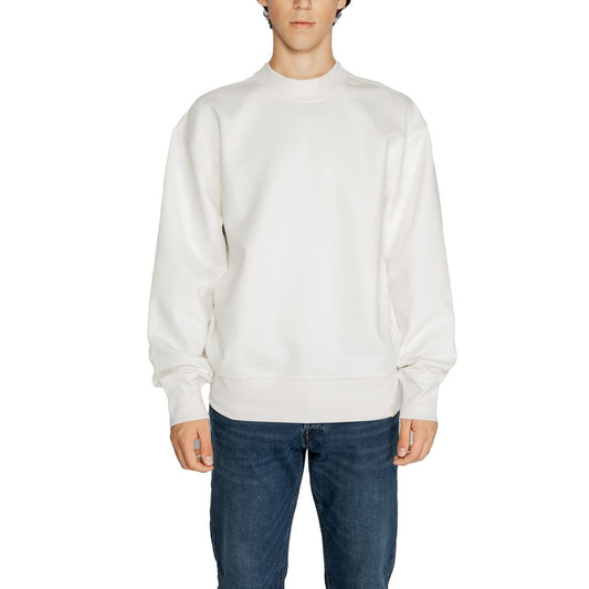 Man wearing Calvin Klein Jeans White Recycled Cotton Sweatshirt with blue jeans, showcasing sustainable fashion.