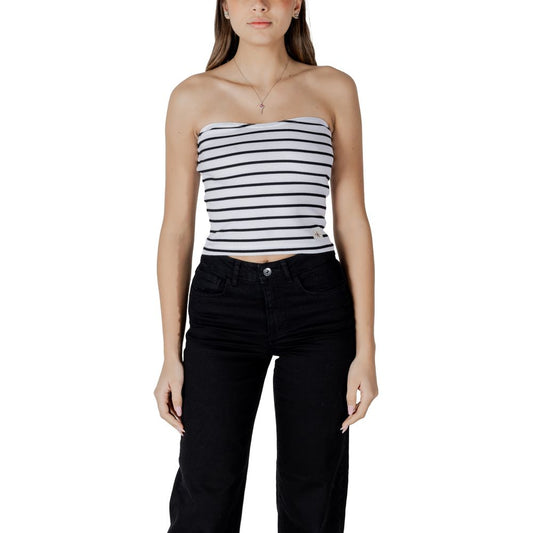 Woman wearing a strapless black and white striped top with black jeans, styling a casual look for everyday wear.
