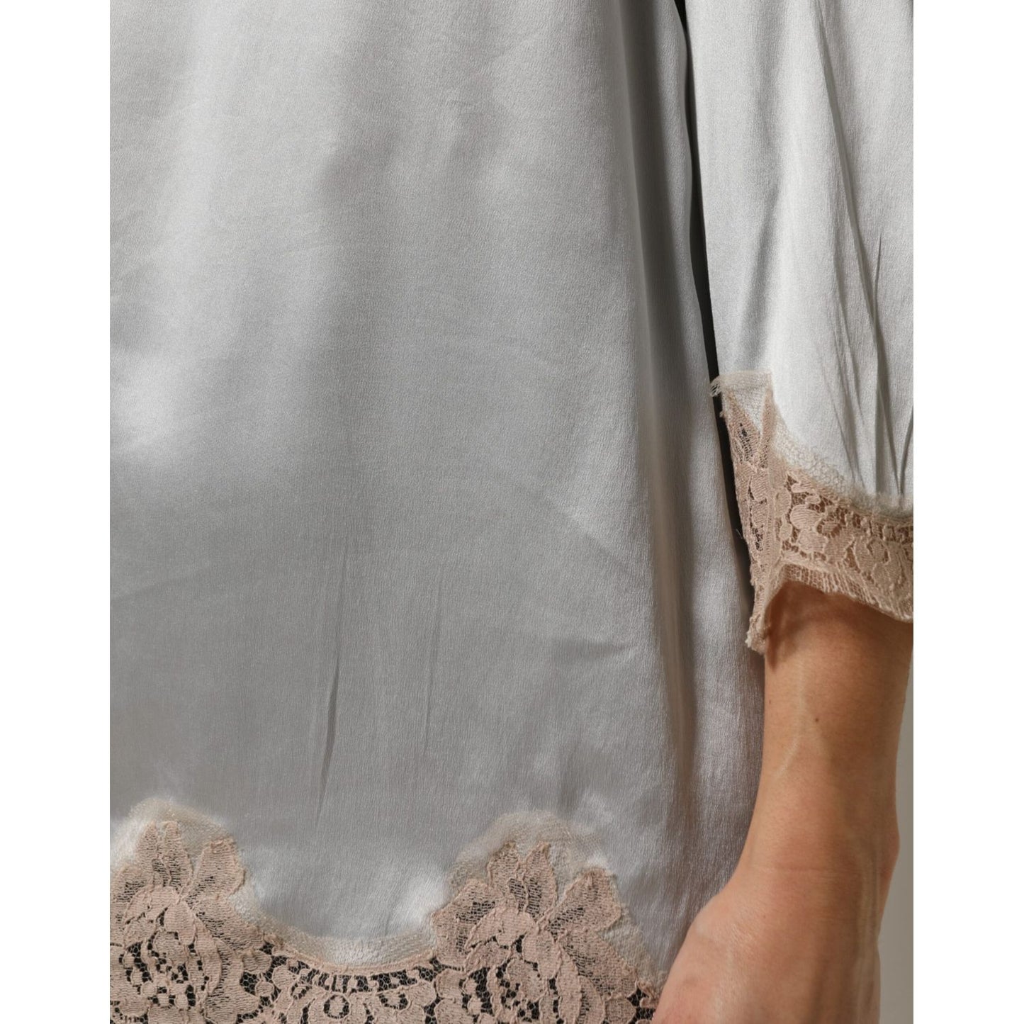 Close-up of Dolce & Gabbana Gray Silk Satin Floral Lace Long Sleeve Top with delicate lace detailing on sleeve and hem.