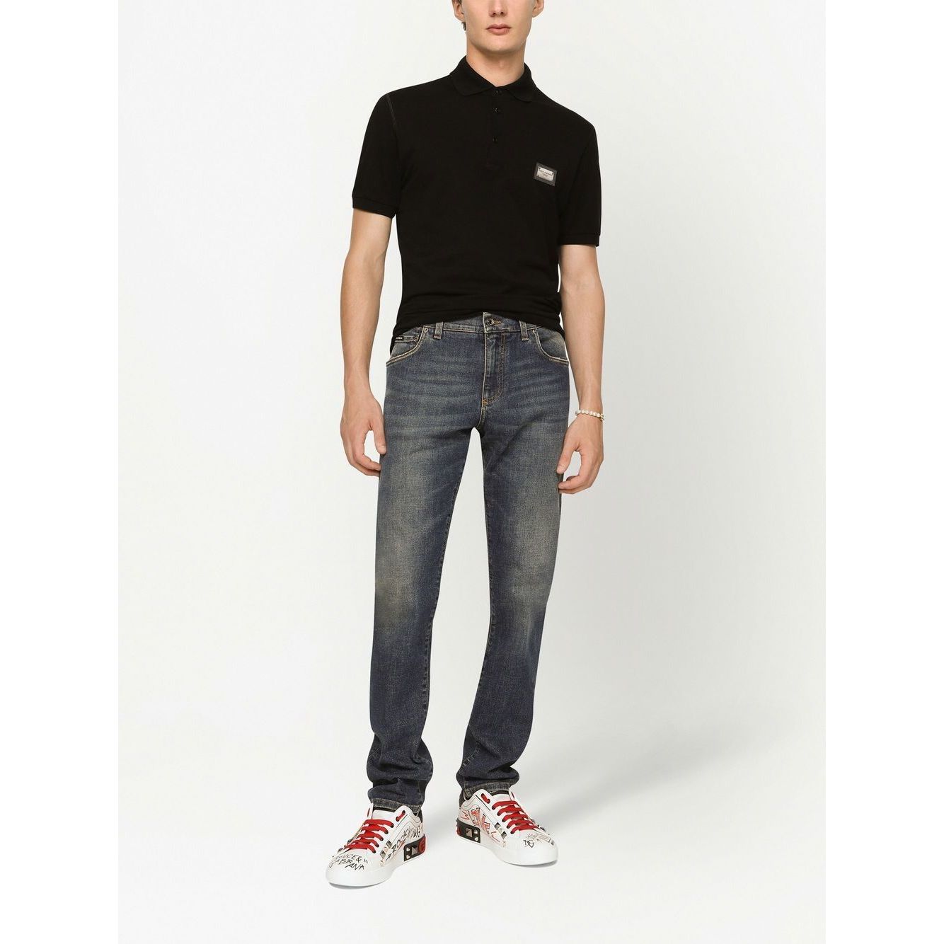 Dolce & Gabbana Logo cotton polo shirt in black with silver-tone logo plaque, paired with jeans and sneakers.