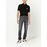 Dolce & Gabbana Logo cotton polo shirt in black with silver-tone logo plaque, paired with jeans and sneakers.