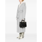 Person holding Emporio Armani MyEA small shopping bag in black faux leather with grained texture and gold-tone hardware, wearing grey coat.