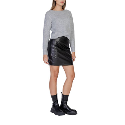 Woman wearing ICHI Black Polyethylene Mini Skirt with grey top and black boots, showcasing modern style and slim fit.
