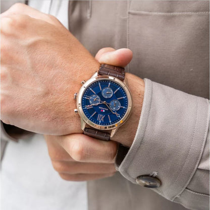 TOMMY HILFIGER Mod. 1710526 men's quartz analog watch with 5 ATM water resistance, 44 mm case, on wrist with brown leather bracelet.