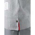 Close-up of side button detail and name tag on grey Thom Browne Sweaters with 4-Bar stripe and ribbed trims.