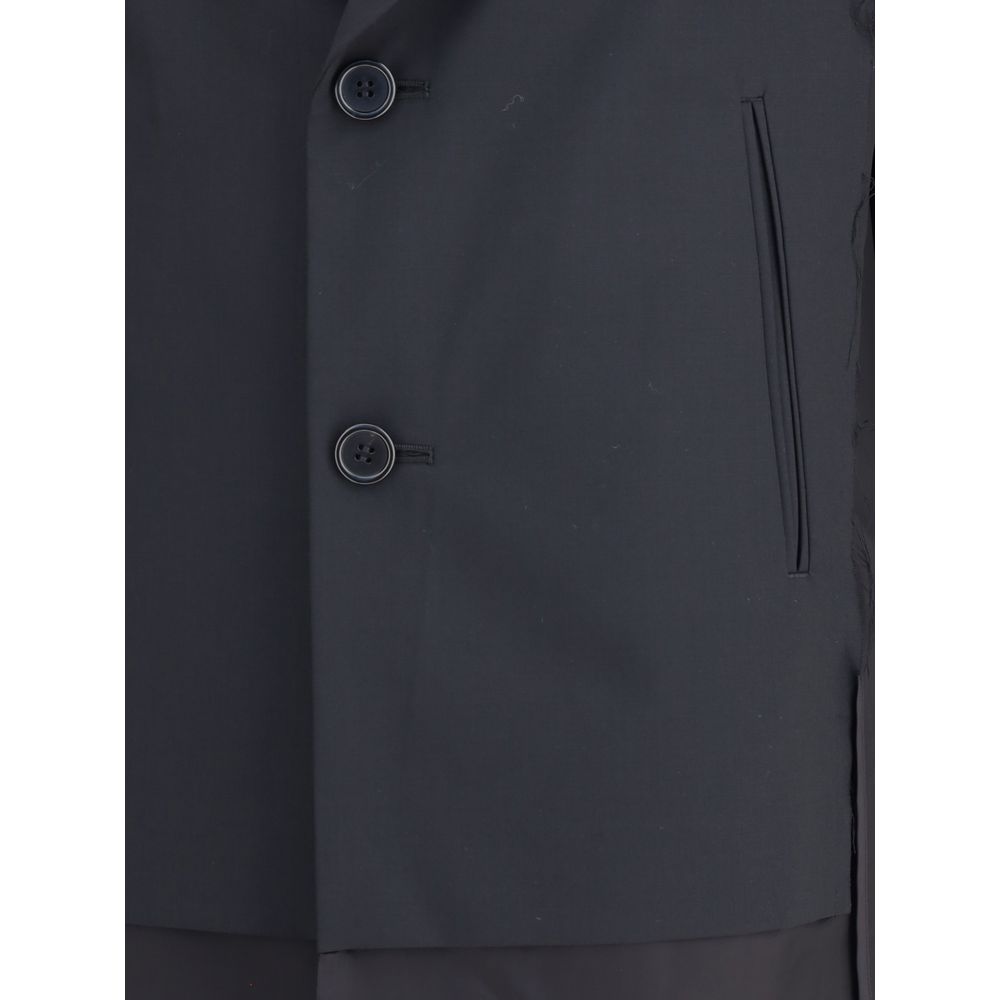 Undercover Black Polyester Coat with paneled design and two-button closure, featuring classic lapels and welt pockets. AW25 collection.