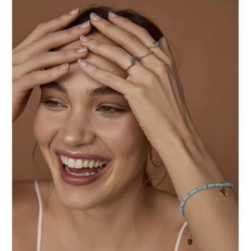 Smiling woman wearing jewelry including a VICEROY JEWELS Mod. 13136A013-33 ring, displaying elegance and style, with hands framing her face.
