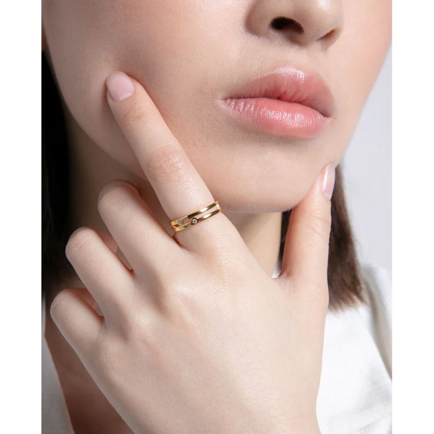 Woman wearing a gold ring on her finger, displaying elegant jewelry style.
