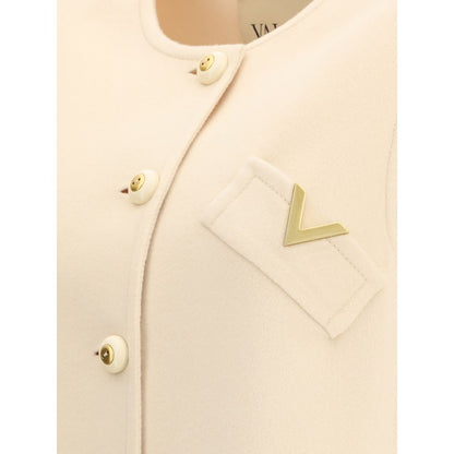 Close-up of Valentino Cream Fleece Wool Clothing vest with button closure, gold V logo, and welt pockets for elegance and warmth.