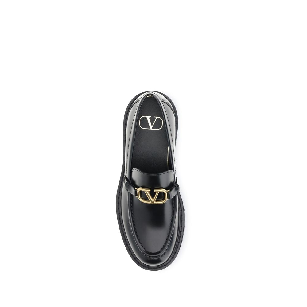 Valentino Garavani Black Leather Slip-On Loafers with VLogo detail and rubber lug sole.