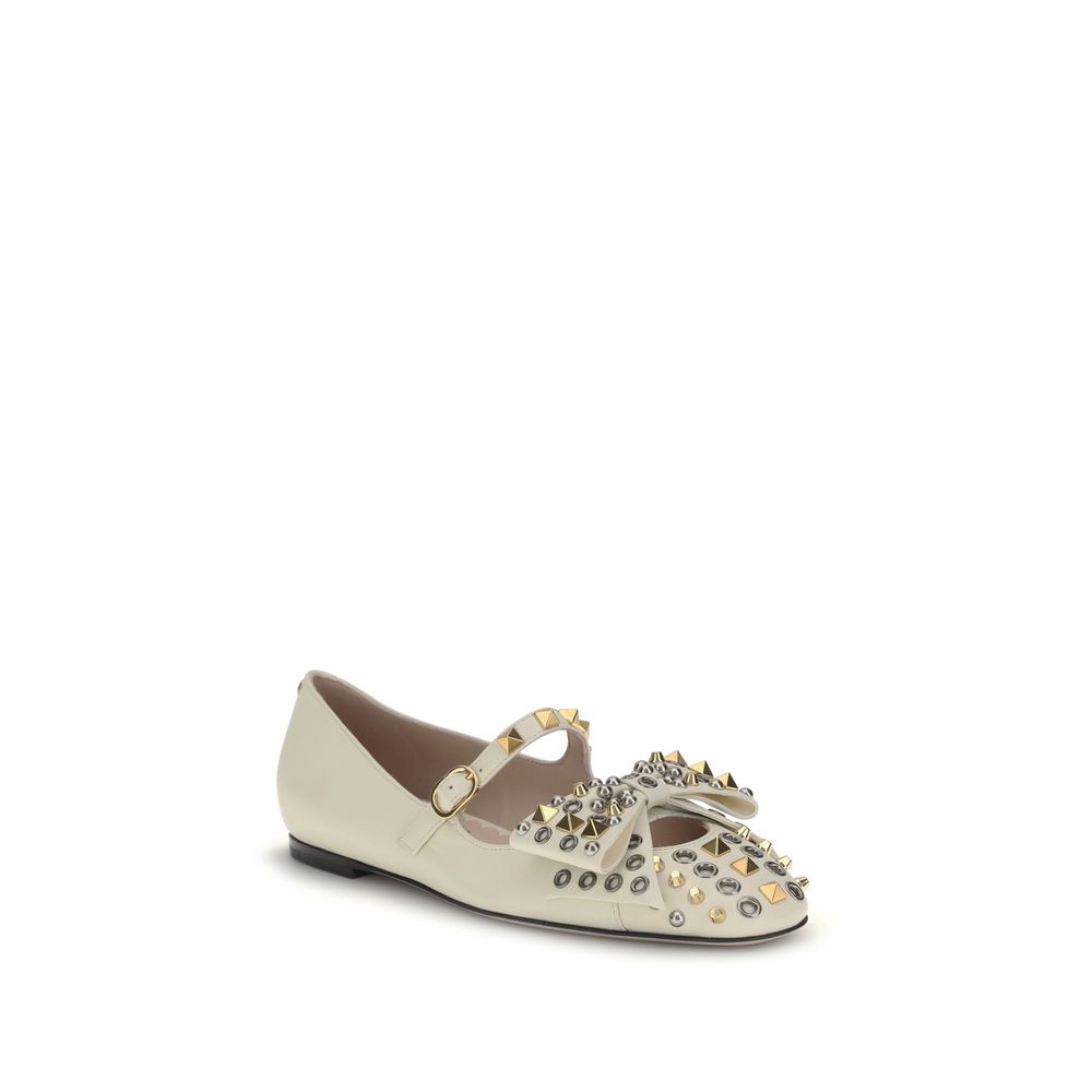 Valentino Garavani Cream Goatskin Ballet Flats with studded design and bow accent, featuring adjustable buckle strap and VLogo detail.